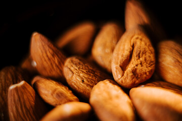 Almonds displayed on a plate against a contrasting black background for a captivating visual effect