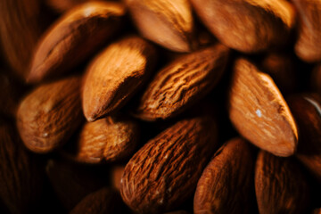 Delicious almonds served in a plate displayed against a striking black background