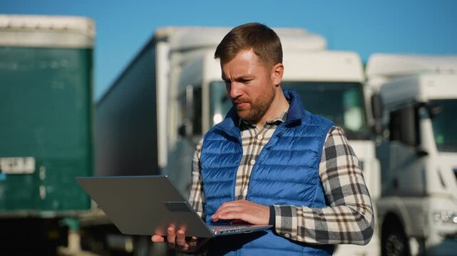 Logistics worker managing fleet operations on laptop
