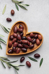 Heart shaped wooden bowl with fresh olives displayed