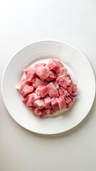 Chunks of raw pork on a white plate, fresh uncooked meat, culinary preparation, protein source