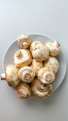 Fresh white mushrooms piled on a plate, ideal for cooking, healthy eating, and vegetarian meals