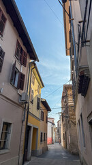 Fototapeta premium Narrow cobblestone alley with rustic European buildings, perfect for travel and exploration concepts, tranquil urban scene