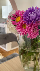 Vibrant pink and purple flowers in glass vase indoors, perfect for Mother's Day, spring decor