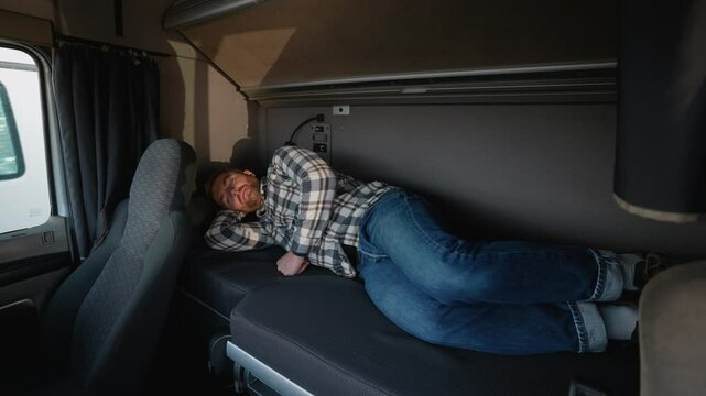 Truck driver lying down to sleep in cabin