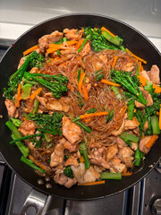 A pan of fried vermicelli wth chicken and vegetables.