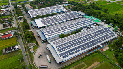 A vast factory rooftop is covered with solar panels, harnessing renewable energy for a greener and...