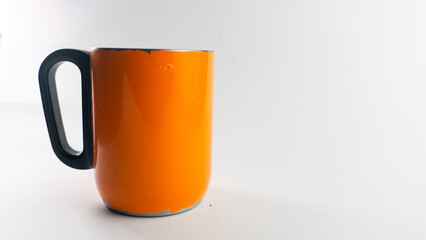 an orange cup whose paint has started to peel off, isolated on white
