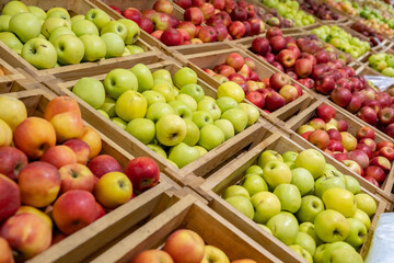 Abundance of apples in crate on counter in supermarket.
