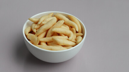 Crunchy Cheese Stick or Cheese Cork Eggs or Telur Gabus Keju or Widaran or Bidaran Keju is an Indonesian traditional snack. It's savory, salty and crispy. Served on a bowl. Grey background