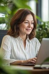 Businesswoman working on laptop in a modern office surrounded by indoor plants, showcasing remote work and productivity in a vibrant environment.
