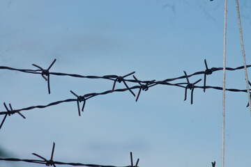 Barbed wire. Barbed wire on fence with blue sky	
