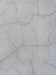 A wall with a rough texture and cracks