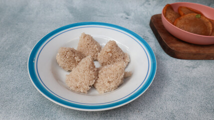 Tiwul, a traditional Indonesian food, is a staple food substitute for rice made from cassava. Usually eaten with a sprinkling of grated coconut. Served in white and blue plate