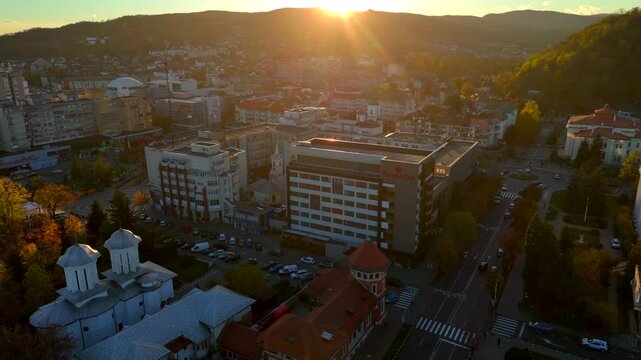 Drone view over cityscape and cars of Ramnicu Valcea City in Romania at sunset