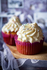 Cupcakes with buttercream for dessert. Beautiful cupcakes with vanilla cream for breakfast. Vertical photo. Close-up