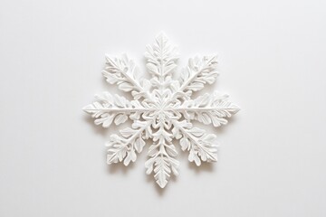 Intricate white snowflake ornament on a plain white background, minimalist winter design.