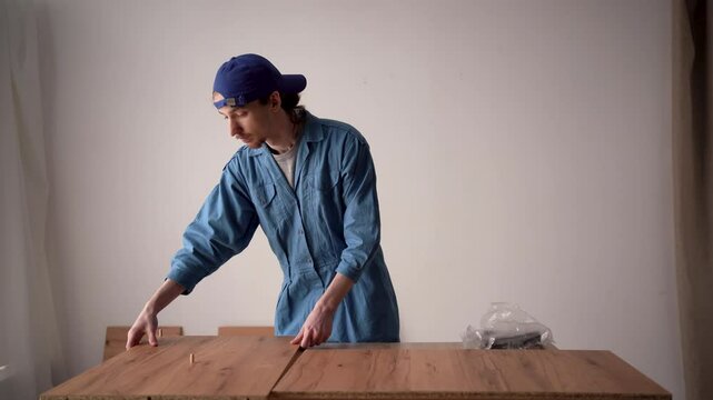 Furniture assembler installing wooden shelf with a wrench. Furniture assembly concept.