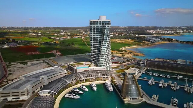 Ayia Napa Cyprus. Bird's eye view of Ayia Napa Marina.
High-rise building and marina on a sunny day. Mediterranean Sea and modern architecture. Nature and urbanism against the backdrop of the sea.
