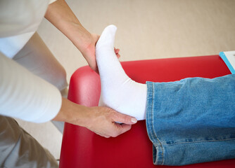 Obraz premium Chiropractor doing physical adjustment on foot of patient in treatment office room. Osteopathic medicine and physiotherapy concept. Chiropractic treatment