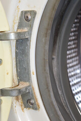 close-up of the rubber gasket and metal drum of a washing machine signs of wear dirt rust buildup...