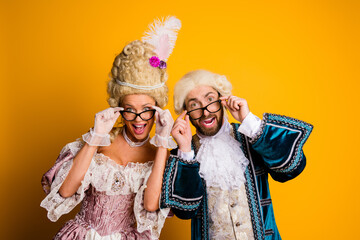 Elegant couple enjoying a retro-themed cosplay with a vibrant yellow background