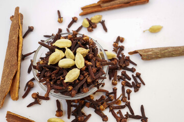 Cardamom, cinnamon, clove, mixed spices isolated on white background. Whole garam masala, Indian spices in selective focus.