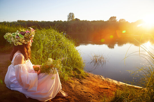Celebrating ancient Slavic traditions during Ivan Kupala by the riverside at sunset