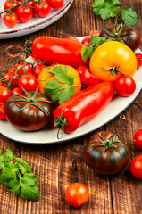 Ripe tomatoes on rustic wooden background.