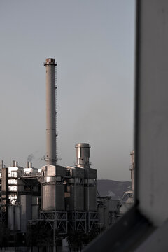 Tall industrial chimney framed by structural elements, emphasizing verticality and scale.