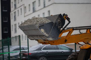 Industrial front loader dropping off gravel in construction project for road construction. 