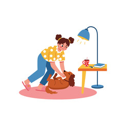 Girl Petting Dog on Floor Near Desk Lamp and Coffee Mug