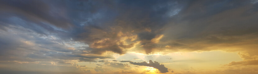 Sunrise sky background. Colourful gold sky with clouds and sun light