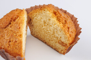 Cut in half cupcake in paper cup on white background.