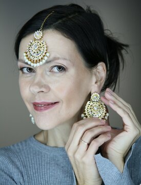 Attractive 51 year old woman wearing Indian jewellery posing for the camera