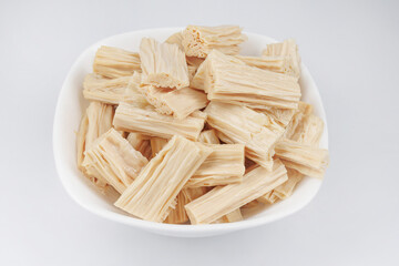 Soy sticks fuzhu in a white plate on a white background. Soy salad. Yuba.