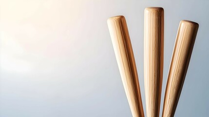 Three Light Brown Wooden Tubes on Gray Background