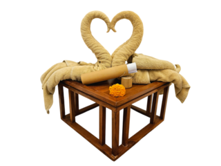 Beautifully arranged towels in the shape of swans forming a heart, complemented by a wooden table, aromatherapy bottle, and a marigold flower for decoration isolated on white background, PNG