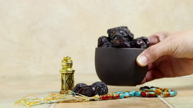 woman hold bowl of Kurma Ajwa, Ajwa Dates, served in traditional metal plate, Kurma Ajwa is one of the special fruit from Madina City with tasbih and oud perfume