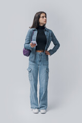 Young woman standing and holding her smartphone