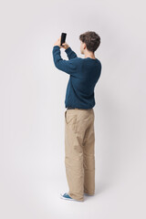 Teenager taking pictures with his smartphone