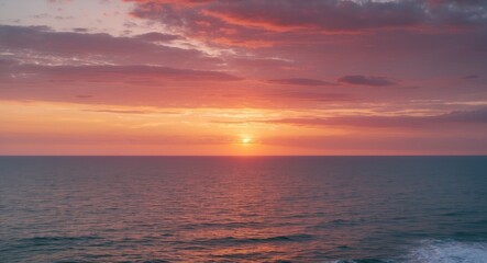 Obraz premium Sunset over calm ocean waters with vibrant clouds reflecting pink and orange hues in the sky during twilight Copy Space