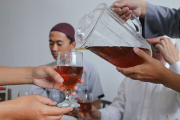 Young Asian Muslim Man Pouring Tea To His Brother During Iftar on Ramadan Moment