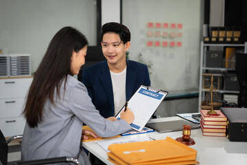 Lawyer signing important legal document on desk at office.