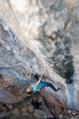 A woman climbs a rock