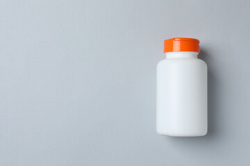 White bottle on gray background, top view