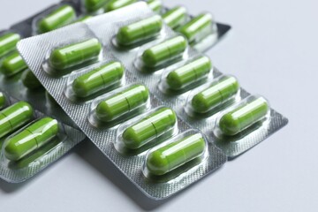 Pills in blister packs on gray background, close up