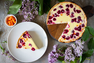 A piece of cherry pie and a cherry pie on a wooden table top view. A piece of berry pie on a white plate. Close-up.