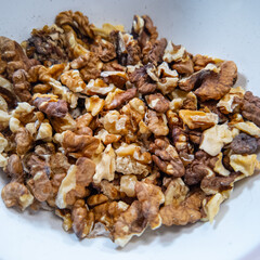 walnuts slow motion video. Whole walnut pieces falling onto white table top and bouncing around before landing in a pile in slow motion. Fistful Of Walnuts Being Dropped On Flat Kitchen Surface