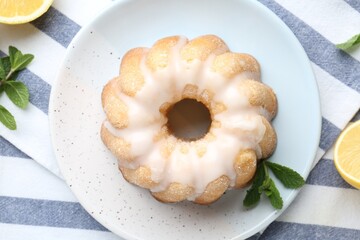 Tasty lemon cake with glaze, fresh fruits and mint on table, flat lay